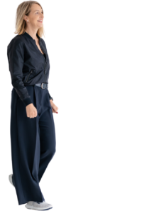 Porträt von Eva Zweidorf im Profil, wie sie von links nach rechts geht, gekleidet in einem dunkelblauen Business-Outfit – eine Darstellung von Fokus, Bewegung und moderner Female Leadership Transformation.